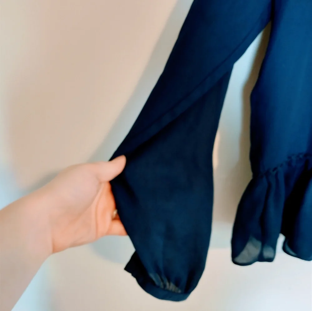 Ana blue long sleeve tunic with peplum detail near the hem and drawstrings at th